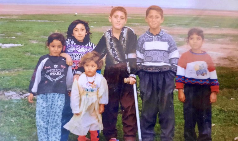 Shahen and her family standing in a field in Iraq. 