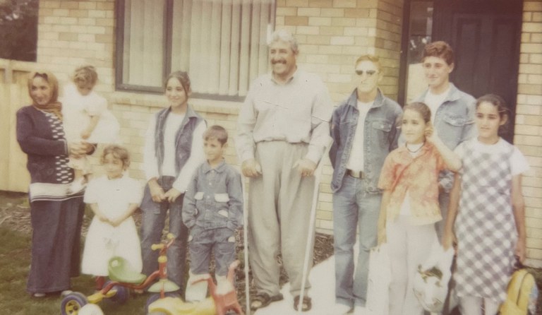 Shahen’s family standing outside a brick house.